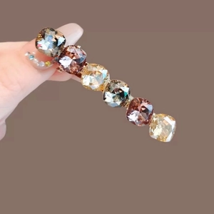 Elegant gold hair clip featuring six square-cut gradient purple and champagne crystals
