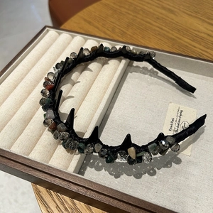 Dettaglio del cerchietto in tessuto nero con pietre colorate e cristalli intrecciati a mano