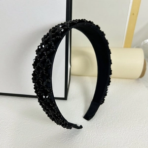 Détail d'un serre-tête large orné de perles noires facettées sur base en tissu