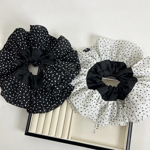 Detailed close-up of large polka dot chiffon scrunchies in black and white colors