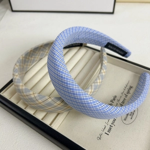 Vue détaillée de serre-têtes en tissu à carreaux faits main avec motifs bleus et étiquette