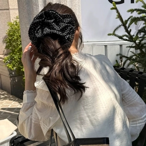 Vintage oversized black polka dot scrunchie styled on a low ponytail in outdoor light