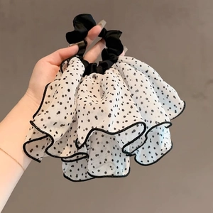 Detailed view of white chiffon scrunchie with black polka dots and pleated ruffles