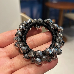 Close-up of silver beaded hair tie with multi-faceted crystal beads on black elastic rope
