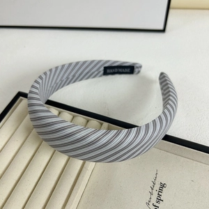 Handmade striped wide headband in grey and white fabric on a velvet display tray