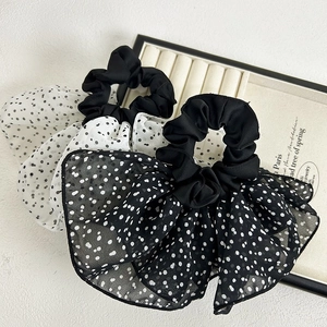 Detail of French-style tulle polka dot bow scrunchies in black and white chiffon fabric