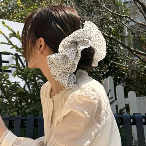 French retro oversized white polka dot hair scrunchie styled on a bun hairstyle