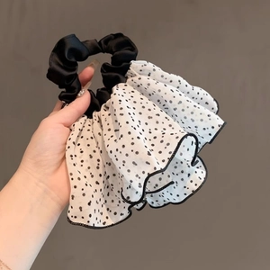 Close-up of black and white polka dot mesh hair scrunchie with layered ruffle pleats