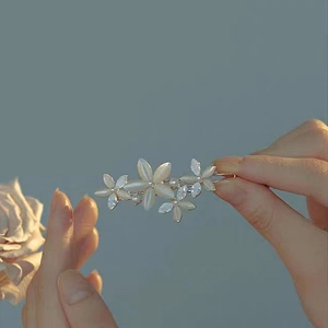 Detail einer eleganten Katzenaugen-Haarklammer mit Opalblüten und glitzernden Strass