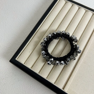 Elegant beaded hair tie with dark grey crystals and black elastic cord on display