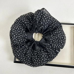 Detailed shot of oversized black polka dot chiffon scrunchie with soft fabric folds