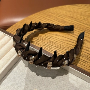 Detail of dark brown satin headband with sparkling rhinestones and integrated hair comb