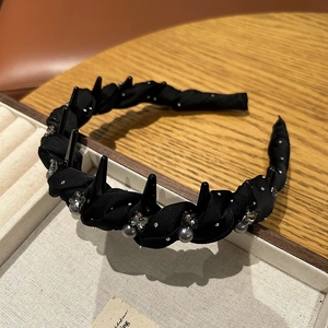 Detail of twisted fabric headband featuring grey pearls, rhinestones and anti-slip teeth