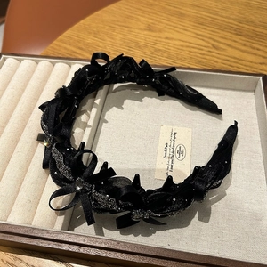 Detail of black ribbon bow headband with sequins and non-slip inner teeth on velvet
