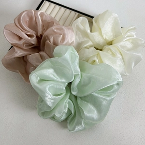 Détail de chouchous géants en texture soie aux tons rose pastel, blanc et vert menthe