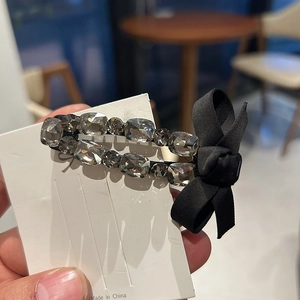 Elegant ribbon bow hair clip with luxury rhinestones and black metal base for women