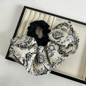 Close-up of black and white Toile de Jouy print on a large French style silk scrunchie
