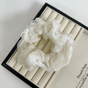 Detail of French style cream organza scrunchie with delicate white lace embroidery edge