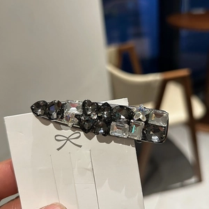 Detail of retro hair clip with heart and star crystals on a white display card