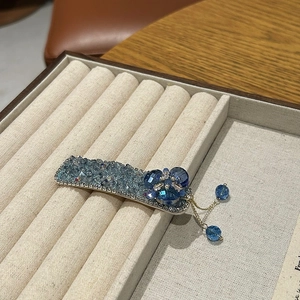 Détail d'une pince à cheveux de luxe en cristal bleu avec fleur en strass et franges