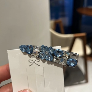 Elegant silver duckbill hair clip featuring blue crystal floral patterns on display card