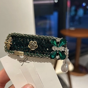 Vintage emerald flower hair clip with golden bees, roses, and hanging pearls detail