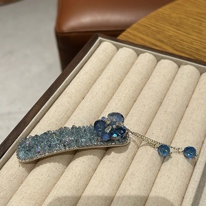 Détail de la barrette à cristaux bleus avec motifs floraux et pampilles dorées fines