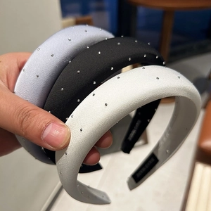 Close-up of three sponge headbands with satin finish and sparkling rhinestones