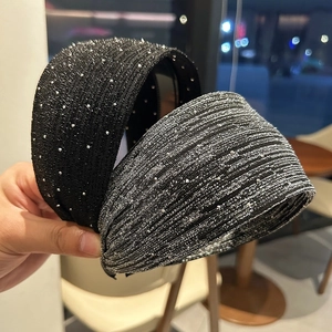 Gros plan de serre-têtes larges scintillants avec strass brillants sur tissu texturé