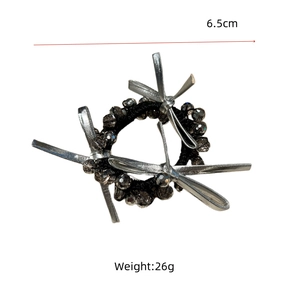 Detail view of 6.5cm hair tie with black beads and silver bows weighing 26g