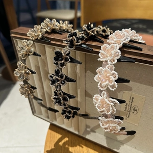 Detailed view of beaded flower headbands in black, champagne, and pink colors