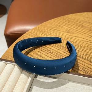 Detailed macro view of handmade navy blue satin headband with sparkling silver beads