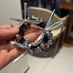 Detail of beaded hair tie with silver bows and faceted dark grey crystal beads