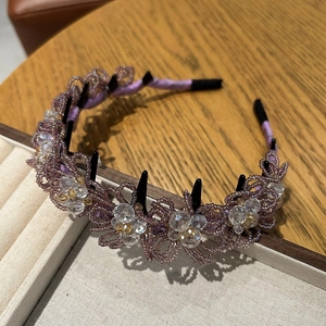 Détail d'un serre-tête perlé violet avec fleurs en cristal et picots intérieurs
