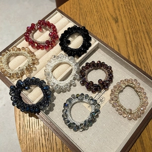 Detail view of 8 assorted crystal beaded hair ties displayed on a jewelry tray
