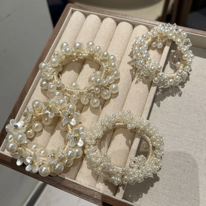 Elegant pearl scrunchie set with camellia floral and crystal details on velvet tray