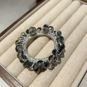 Sparkling crystal beaded elastic hair tie displayed on a premium beige jewelry case