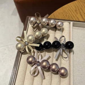 Détail de barrettes à nœuds avec perles et strass élégants en plusieurs coloris