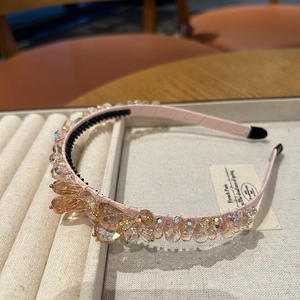 Détail d'un serre-tête rose clair avec pierres champagne et peigne intérieur antidérapant