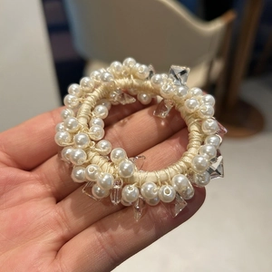 Detailed close-up of pearl and crystal mesh hair scrunchie with elegant beads