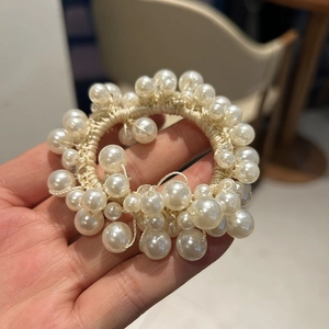 Close-up of elegant pearl hair tie with creamy white faux pearls and high elasticity