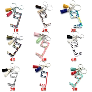 Close-up of patterned non-contact door opener tools with colorful tassels and keychains