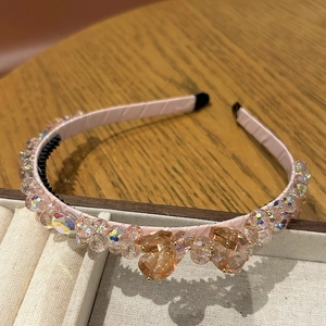 Détail d'un serre-tête rose en cristal avec perles facettées et dents intérieures antidérapantes