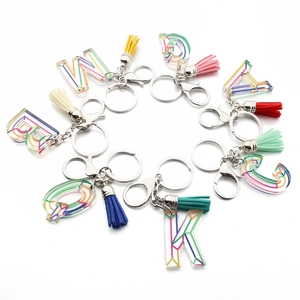 Acrylic alphabet keychain with colorful tassel and silver ring on white background