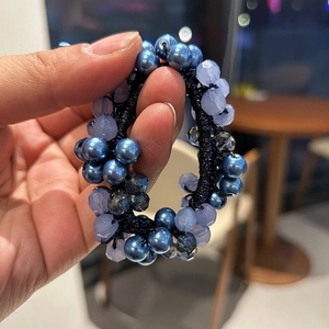 Dettaglio di elastico per capelli con perline di cristallo blu e gemme sfaccettate