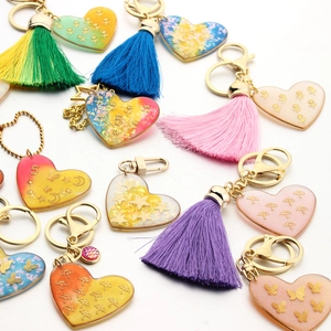 Detailed macro view of heart resin keychains with colorful gradients and silk tassels