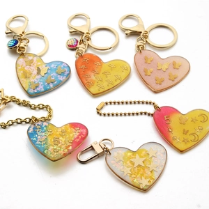 Colorful heart resin keychains with gold butterfly charms and glitter flake gradients