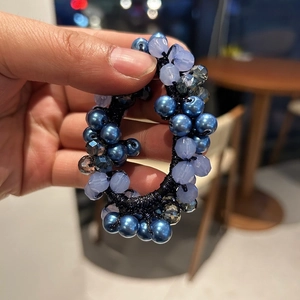 Dettaglio elastico per capelli in cristallo con perle blu scuro e perline in resina