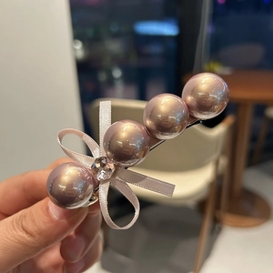 Détail d'une pince à cheveux avec perles roses, nœud en soie et strass pour femmes