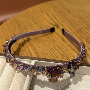 Détail du serre-tête en soie lavande avec des cristaux ambrés et violets scintillants